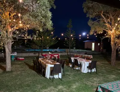 a group of tables and chairs in a yard at night at Villa Rancho losindios