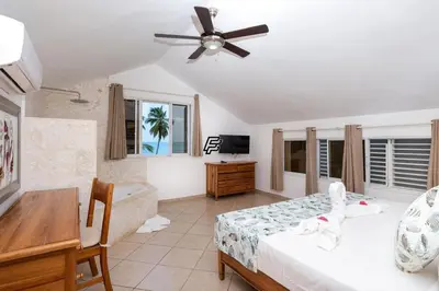 a bedroom with a bed and a ceiling fan at Luxury Penthouse in front of the Sea in Las Terrenas in Las Terrenas
