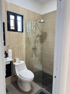 a bathroom with a toilet and a glass shower at Nashaly suite in Arroyo El Cabo
