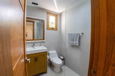 a bathroom with a toilet and a sink and a mirror at La Vega Villa with Private Pool and BBQ in Concepción de La Vega
