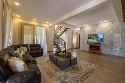 a living room with a leather couch and a tv at La Vega Villa with Private Pool and BBQ in Concepción de La Vega