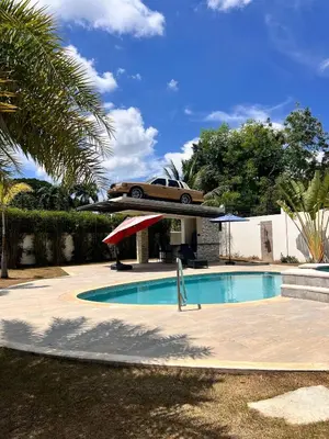 a car is flying over a swimming pool at La Vega Villa with Private Pool and BBQ in Concepción de La Vega