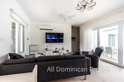 a living room with a couch and a tv at Sosua Ocean Village, Villas 24 in Sosúa