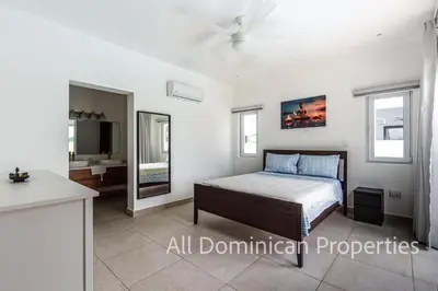 a bedroom with a bed and a bathroom with a sink at Sosua Ocean Village, Villas 24 in Sosúa