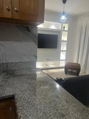 a kitchen with a counter top with a tv on a wall at Burungos Place at Terrazas del Caribe in Ensanche Savica de Mendoza
