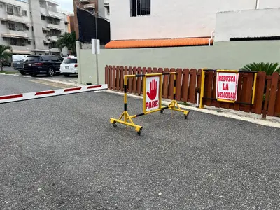 two signs on a street next to a fence at Burungos Place at Terrazas del Caribe in Ensanche Savica de Mendoza