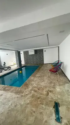 a room with a swimming pool and a chair at Estancia Rincon del AMOR in Juan López
