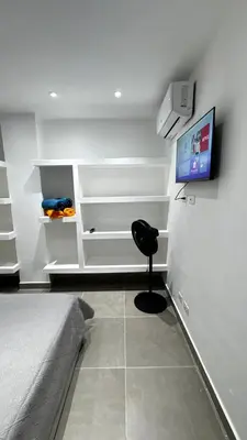 a room with a bed and a chair and a television at Estancia Rincon del AMOR in Juan López