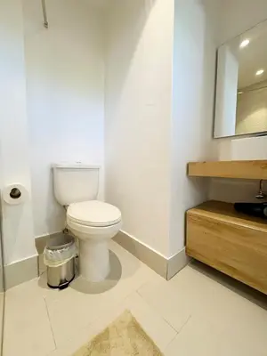 a white bathroom with a toilet and a mirror at Garden Suite Vista Golf E-105 in Colorado