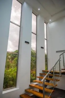 a staircase in a building with large windows at Great villa with pool table in La Romana