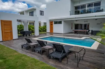 a villa with a swimming pool and a house at Great villa with pool table in La Romana