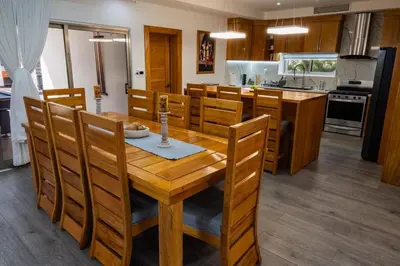 a kitchen and dining room with a wooden table and chairs at Great villa with pool table in La Romana