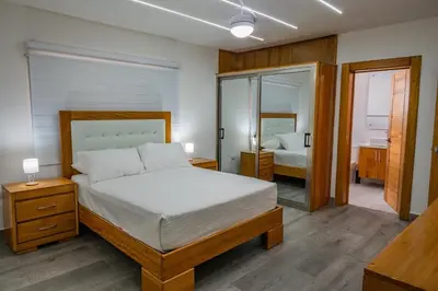 a bedroom with a large bed and a mirror at Great villa with pool table in La Romana