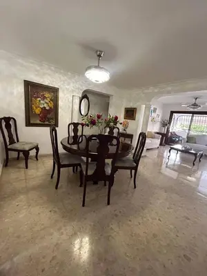 a living room with a dining room table and chairs at Cozy apartment in Piantini city center in Santo Domingo