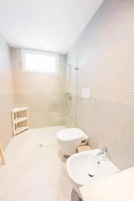 a white bathroom with a toilet and a sink at Hydra 103 Poolview Luxury Apt Dominicus in La Laguna