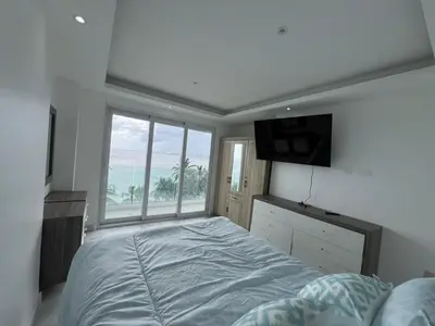 a bedroom with a large bed and a large window at Boca Beach 504, Boca Chica in Boca Chica