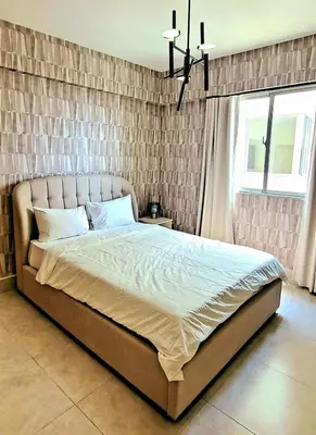 a bed in a bedroom with a brick wall at Residential Boca del Mar Tower III Apart 802 in Boca Chica