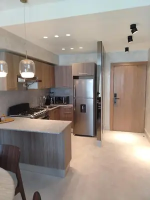 a kitchen with a stainless steel refrigerator and wooden cabinets at Residential Boca del Mar Tower III Apart 802 in Boca Chica