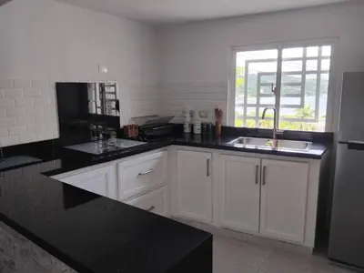 a kitchen with white cabinets and a sink and a window at Villa de Angela en Samana in Sabana