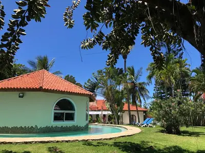 a house and a swimming pool in a yard at Villa twin palm in Sosúa