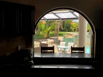 an arched window with two chairs and a patio at Villa twin palm in Sosúa
