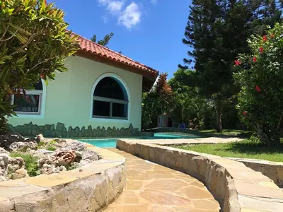 a house with a swimming pool next to a yard at Villa twin palm in Sosúa