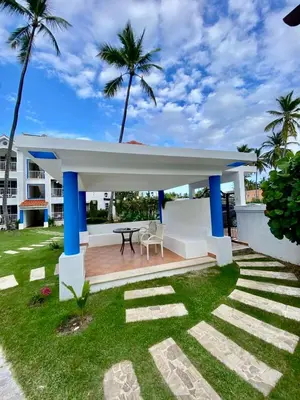 a backyard with a white and blue pavilion with palm trees at Vista del Sol Pool and Beach los Corales Rd in Punta Cana