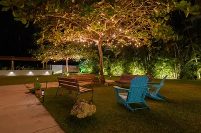 a group of park benches sitting under a tree with lights at New! Gorgeous Portillo Beach Villa W Pool & Staff in Abra Grande