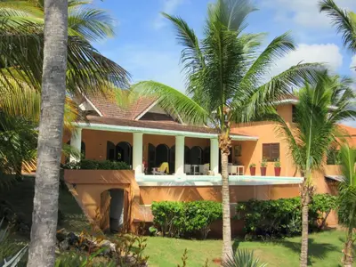 a house with palm trees in front of it at Villa Los Gorgones in Las Galeras