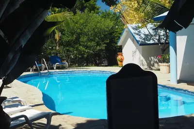 a swimming pool with a chair and a table and a chairitures at Residencial Estephany in Sosúa