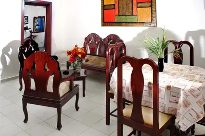 a dining room with a table and two chairs and a table with flowers at Residencial Estephany in Sosúa