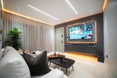 a living room with a white couch and a tv at Fj Luxury Apartment in Santiago de los Caballeros