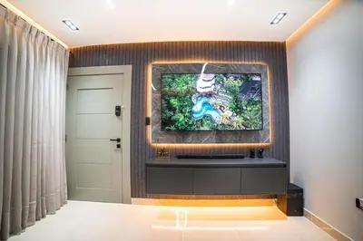 a living room with a television on a wall at Fj Luxury Apartment in Santiago de los Caballeros