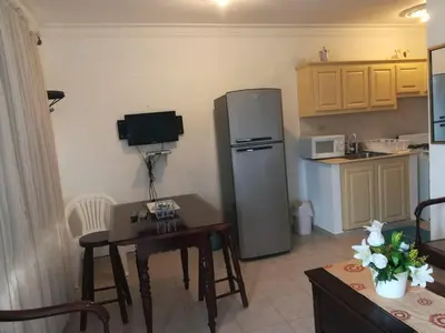 a kitchen with a refrigerator and a table with chairs at Estancia Marina 101 in Boca Chica