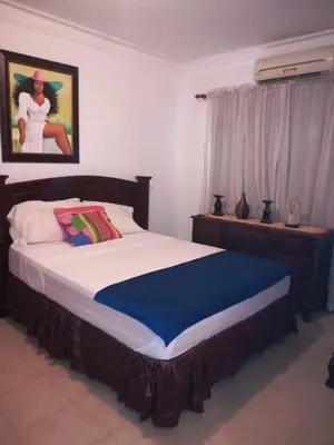 a bedroom with a large bed with a blue blanket at Estancia Marina 101 in Boca Chica