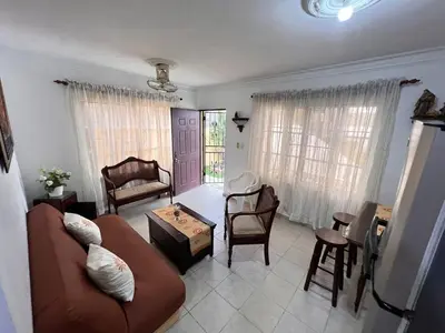a living room with a couch and chairs and a table at Estancia Marina 101 in Boca Chica