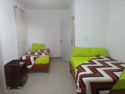 a room with two beds and a couch in it at Villa club turístico tu ancla in Los Alcarrizos