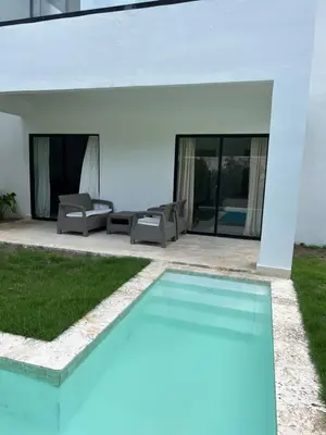 a swimming pool in front of a house at Swim up and Beach Getaway at White Sands in Punta Cana