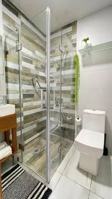 a bathroom with a glass shower with a toilet at Lujoso apartamento en Piantini in Santo Domingo