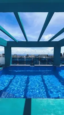 a large swimming pool with a view of a city at Lujoso apartamento en Piantini in Santo Domingo