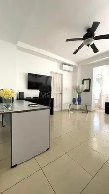 a living room with a ceiling fan and a table at Relaxing and cozy apartment in Gazcue in Santo Domingo