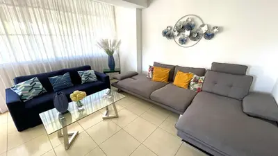 a living room with a couch and a table at Relaxing and cozy apartment in Gazcue in Santo Domingo