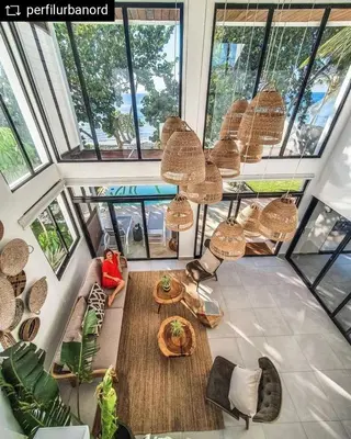 a living room with a lot of windows at Bayshore 76 Beachfront Villa Palmar de ocoa in Palmar de Ocoa