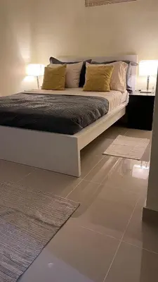 a bedroom with a bed with two lamps and a rug at Apartamento cerca de todo en SDE in Santo Domingo