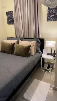 a bedroom with a bed and a table with a lamp at Apartamento cerca de todo en SDE in Santo Domingo