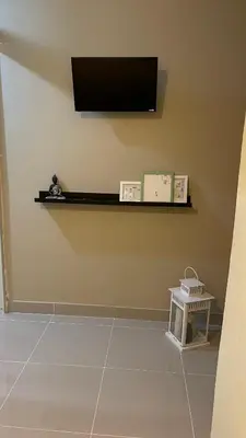 a room with a tv on a wall with a shelf at Apartamento cerca de todo en SDE in Santo Domingo