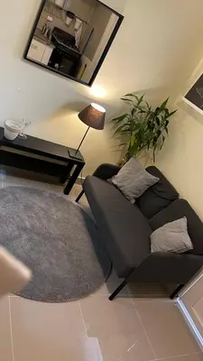 a living room with a black couch and a rug at Apartamento cerca de todo en SDE in Santo Domingo