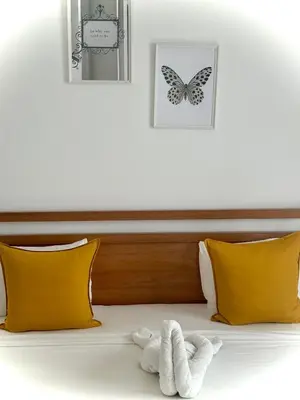 a bed with two yellow pillows and a stuffed animal at Modern apartament near the sea-Las Terrenas in Las Terrenas