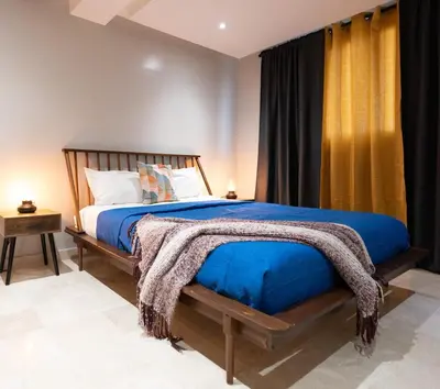 a bedroom with a large bed with a blue comforter at City Center, 2-BR Suite close to Shops, Restaurants, Bars and More in Santo Domingo