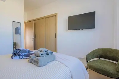 a bedroom with a bed with towels and a chair at PB 3 hab | con piscina privada + laguna cristalina in Punta Cana